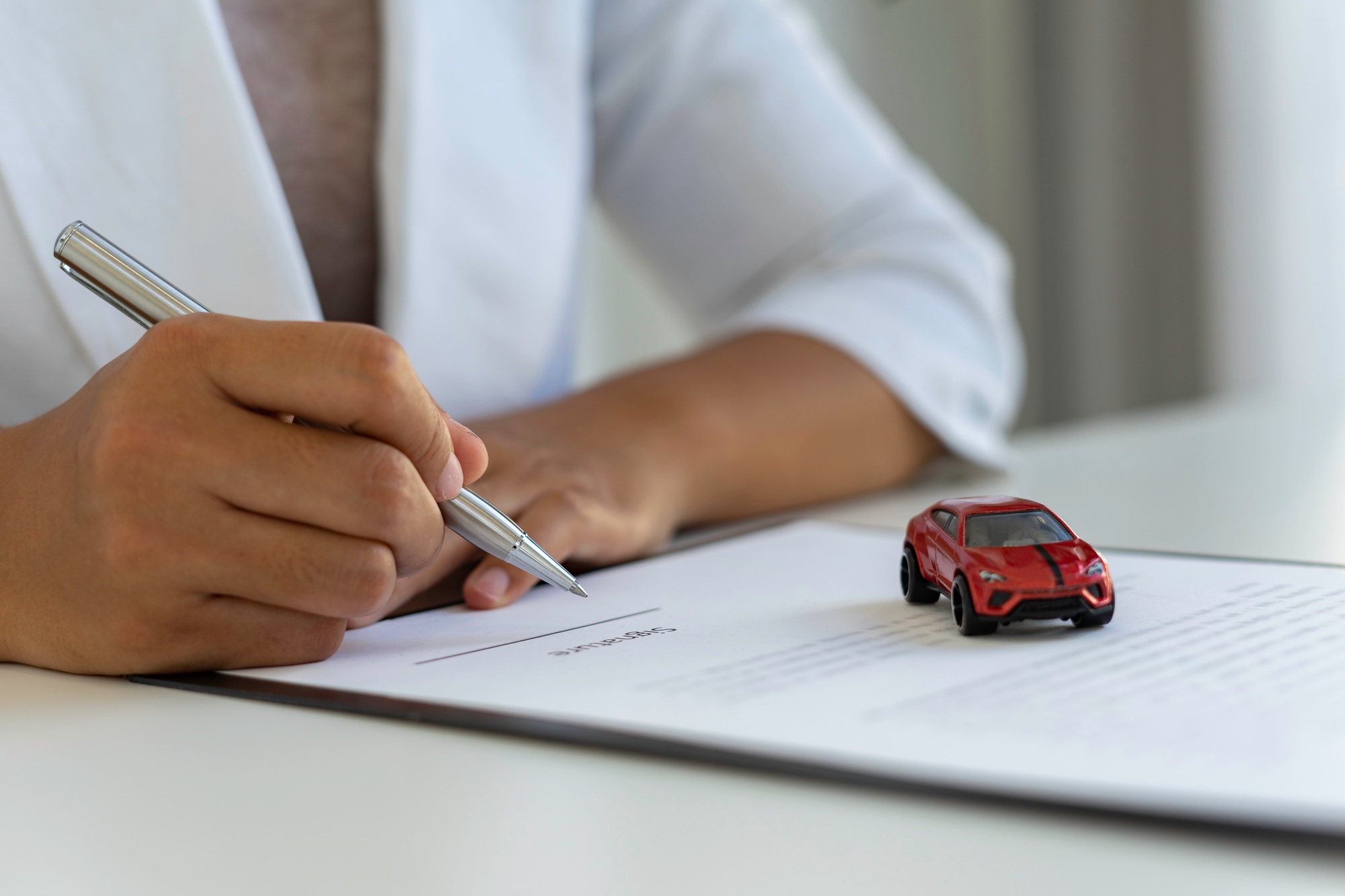 The insurance agent is letting the insured sign the contract. After the concept of car insurance. An